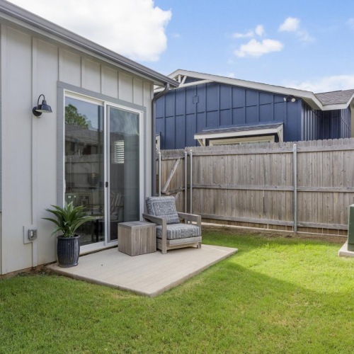 a building with a fence and a lawn in front of it