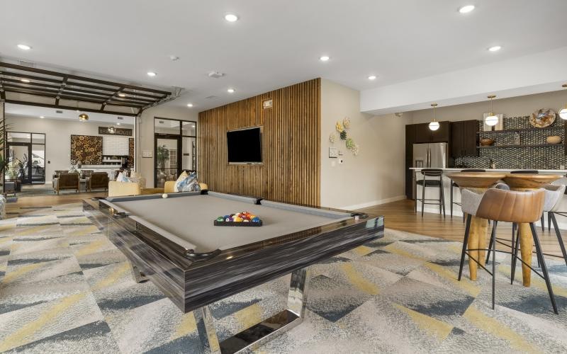 a room with a pool table and chairs